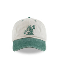 A baseball cap that has beige panels and a pigment washed green bill. On the front of the cap is an embroidered design of a TV character smiling and waving. From the Try Guys.