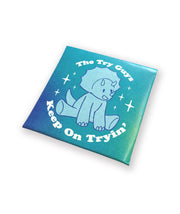 A folded envelope that has a colorful design. The design is of a triceratops and text that reads "The Try Guys" and "Keep On Tryin'". From the Try Guys.