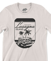 A closeup of an off-white shirt with a design printed in black on the front. The design is of a round, pill-shaped border with a lasagna floating atop the sea. Two palm trees are sprouting from the lasagna. Above the is text that reads "World Famous Lasagna Island." From the Try Guys.