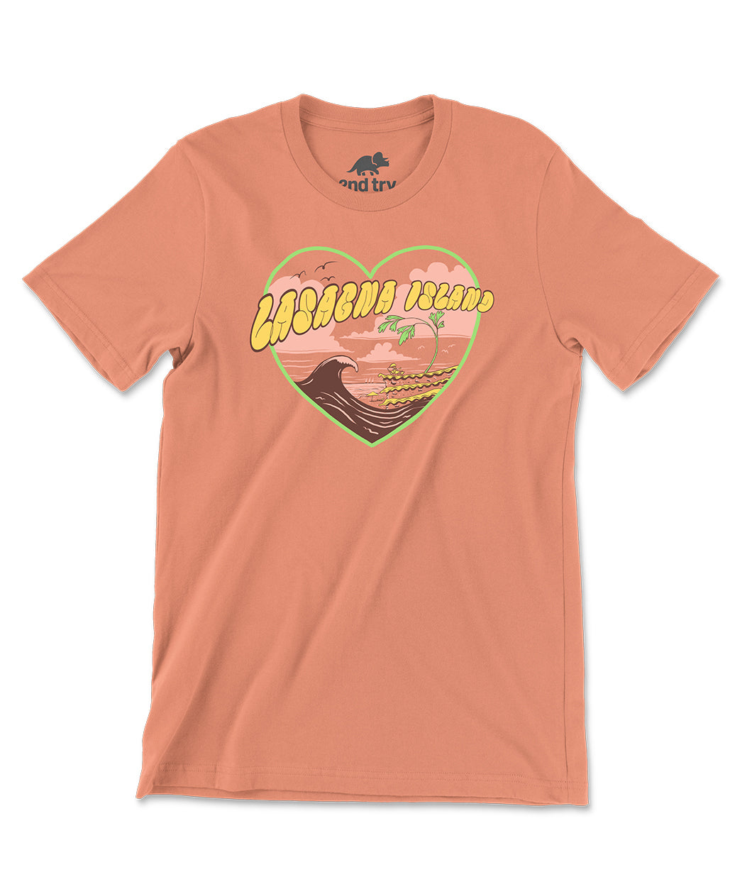 A peach-pink t-shirt with a design of an ocean wave coming up onto the beach of a lasagna island. The design is surrounded by a heart-shaped frame and has text over it that reads, "Lasagna Island". From the Try Guys.