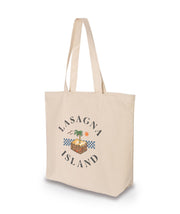 A three-quarters view of a large canvas tote bag with a design on its side. The design is of a piece of lasagna with a palm tree sprouting in the center, and birds and a sun in the background. Circling around the illustration is text that reads. "Lasagna Island." From the Try Guys.