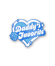 An enamel pin with the phrase, "Daddy's Favorite". The phrase is surrounded by a heart and has a winking triceratops. From the Try Guys.