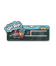 An enamel pin of a trolley with Zach's face on it, running on a track. From the trolley is a plume of smoke with text that reads, "Uh-Oh!". From the Try Guys.