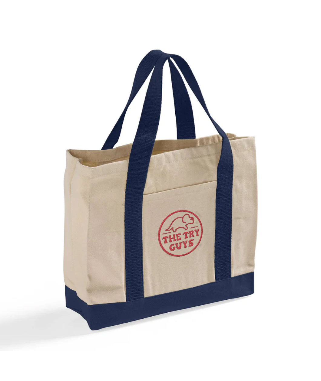 3/4 view of a canvas bag with navy bottom and handles featuring a front pocket embroidered with a red design of the Tryceratops logo and the text "The Try Guys"