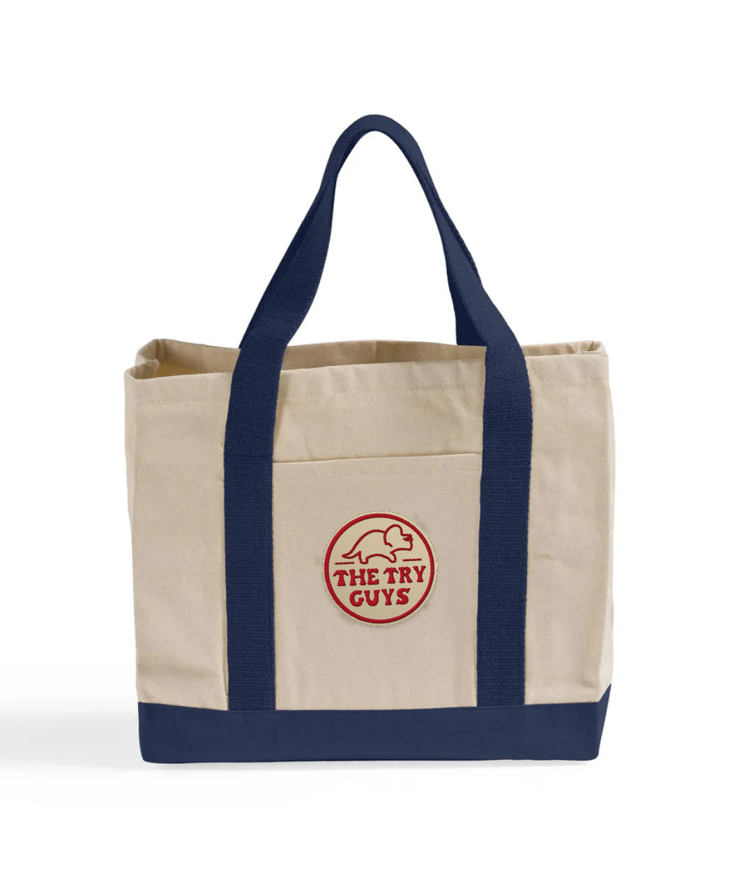 Front view of a canvas bag with navy bottom and handles featuring a front pocket with an embroidered patch with a red design of the Tryceratops logo and the text "The Try Guys"