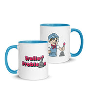 A white ceramic mug with a blue handle and interior. The mug has a design of the Trolley Problems logo on one side and Conductor Zach on the other. From the Try Guys.